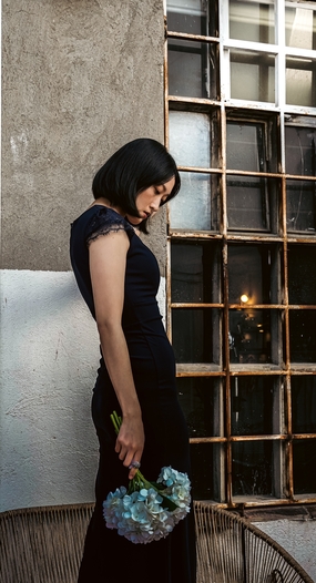 低眸手持花束的黑色长裙美女图片